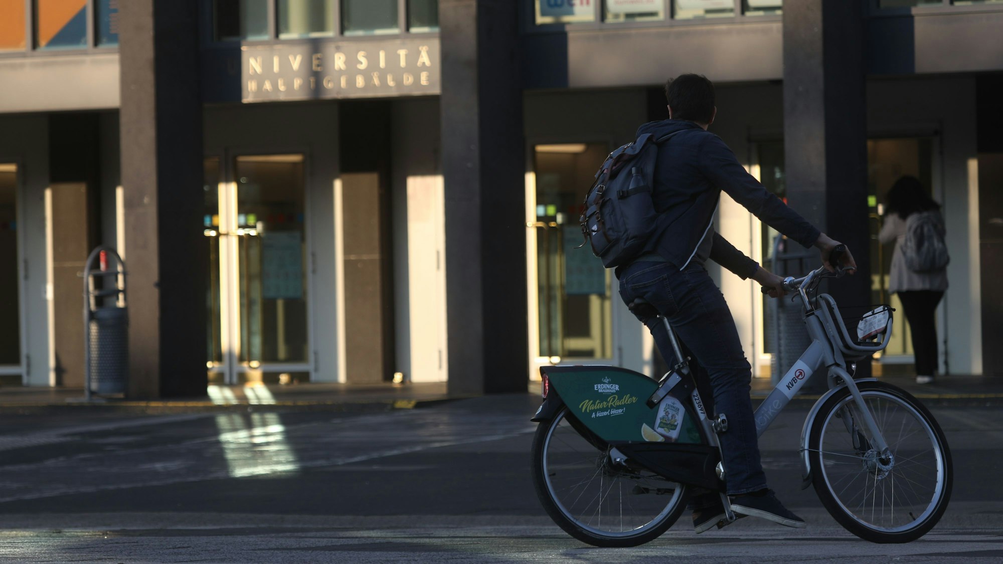 Ein Student fährt mit einem Leihrad der KVB zur Uni.