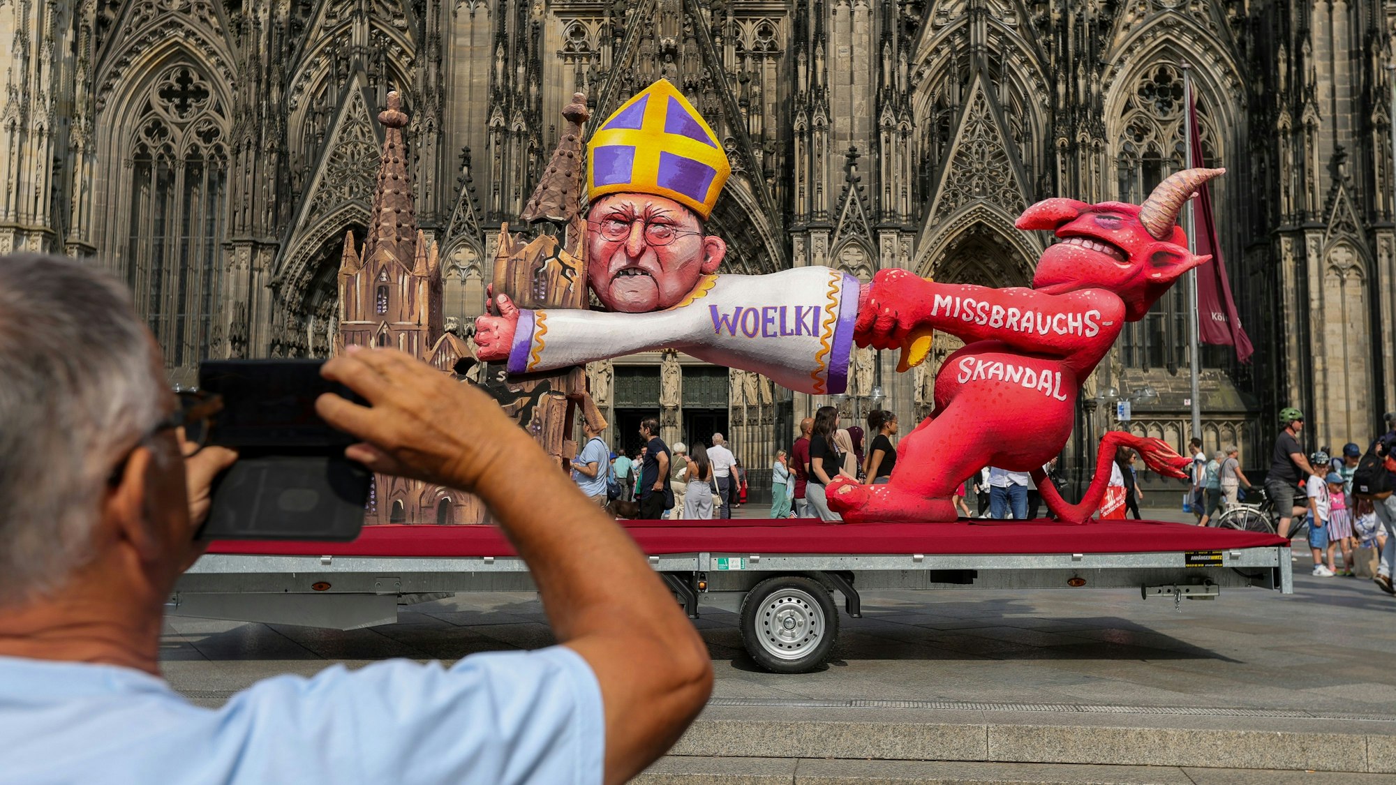 Protestaktion am Freitag vor dem Kölner Dom: Der berühmte Wagenbauer Jacques Tilly kritisiert den Kölner Kardinal Woelki mit einem Persiflagewagen.