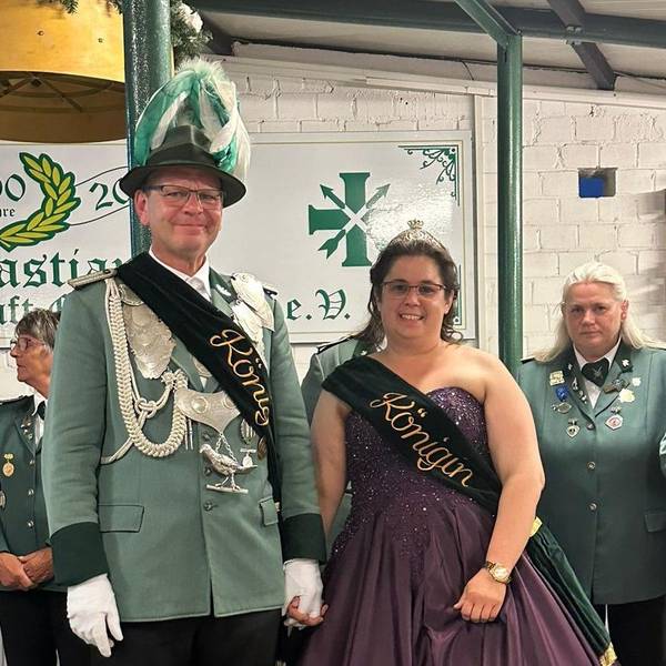 Das Foto zeigt einen Mann in Schützenuniform und eine Frau im Ballkleid, beide mit Schärpe.