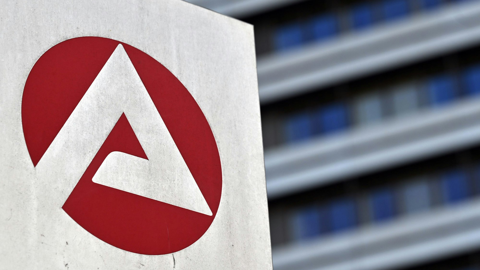 Das Logo der Bundesagentur für Arbeit ist auf einer Stele vor dem Gebäude angebracht.