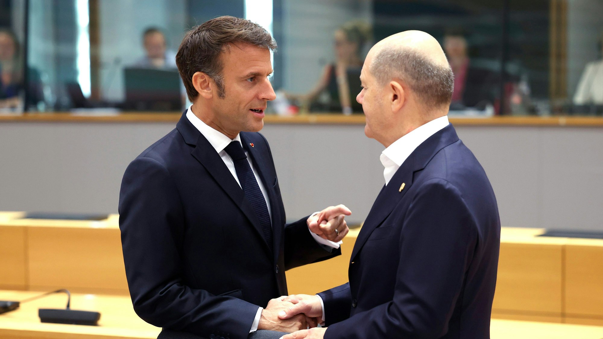Belgien, Brüssel: Emmanuel Macron, Präsident von Frankreich, spricht mit Bundeskanzler Olaf Scholz (SPD), während eines Treffens am runden Tisch im Gebäude des Europäischen Rates am zweiten Tag eines EU-Gipfels. Foto: Geert Vanden Wijngaert/AP/dpa +++ dpa-Bildfunk +++