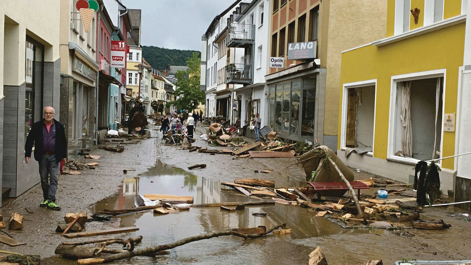 Dreiborner Straße in Gemünd nach dem Hochwasser. Auf dem Boden liegt Schlamm und Sperrmüll, die Geschäfte im Erdgeschoss sind zerstört.