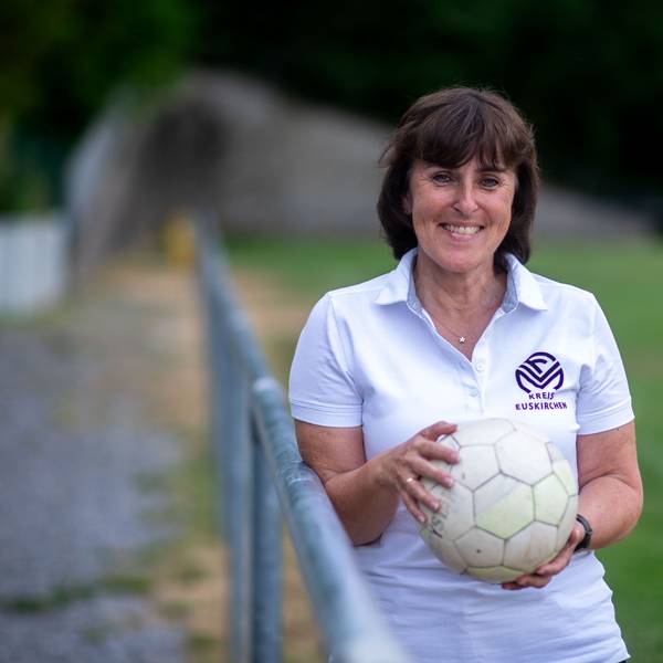 Doris Mager lehnt an eine Absperrstange und hält einen Ball in ihren Händen.