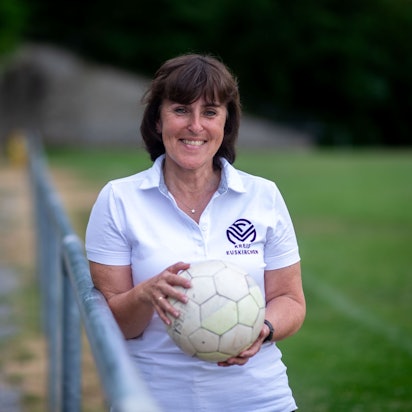Doris Mager lehnt an eine Absperrstange und hält einen Ball in ihren Händen.