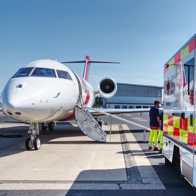 Ein Krankenwagen steht vor einem Flugzeug.