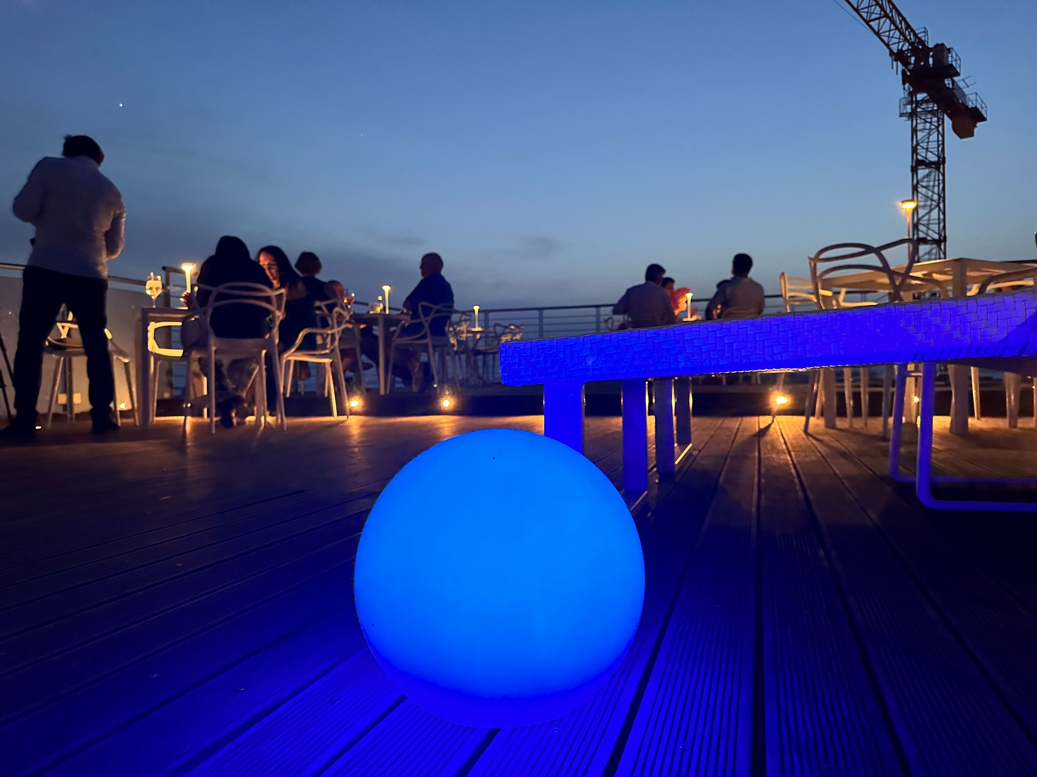 Eine Dachterrasse wird in ein blaues Licht gehüllt.
