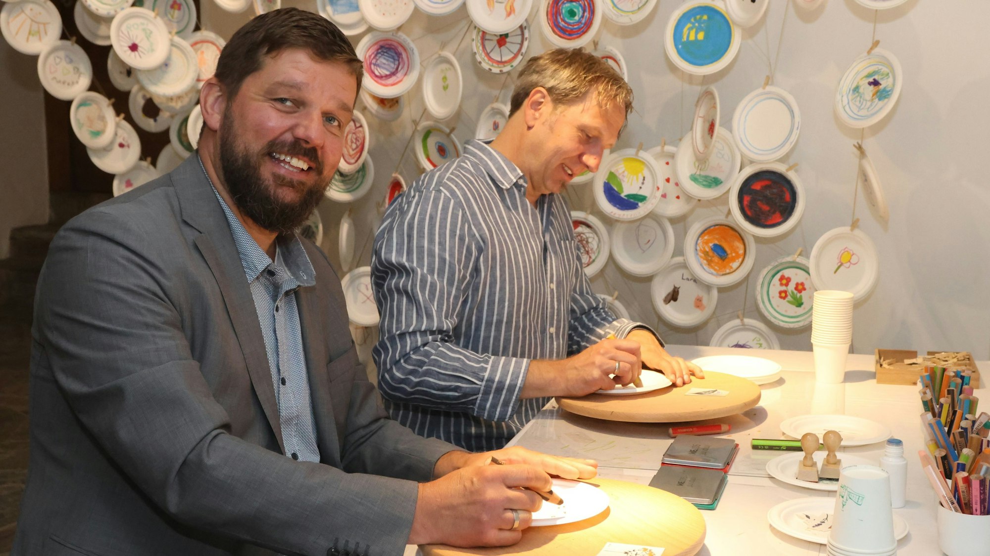 Felix Ammann und Steffen Müller bemalen Teller.