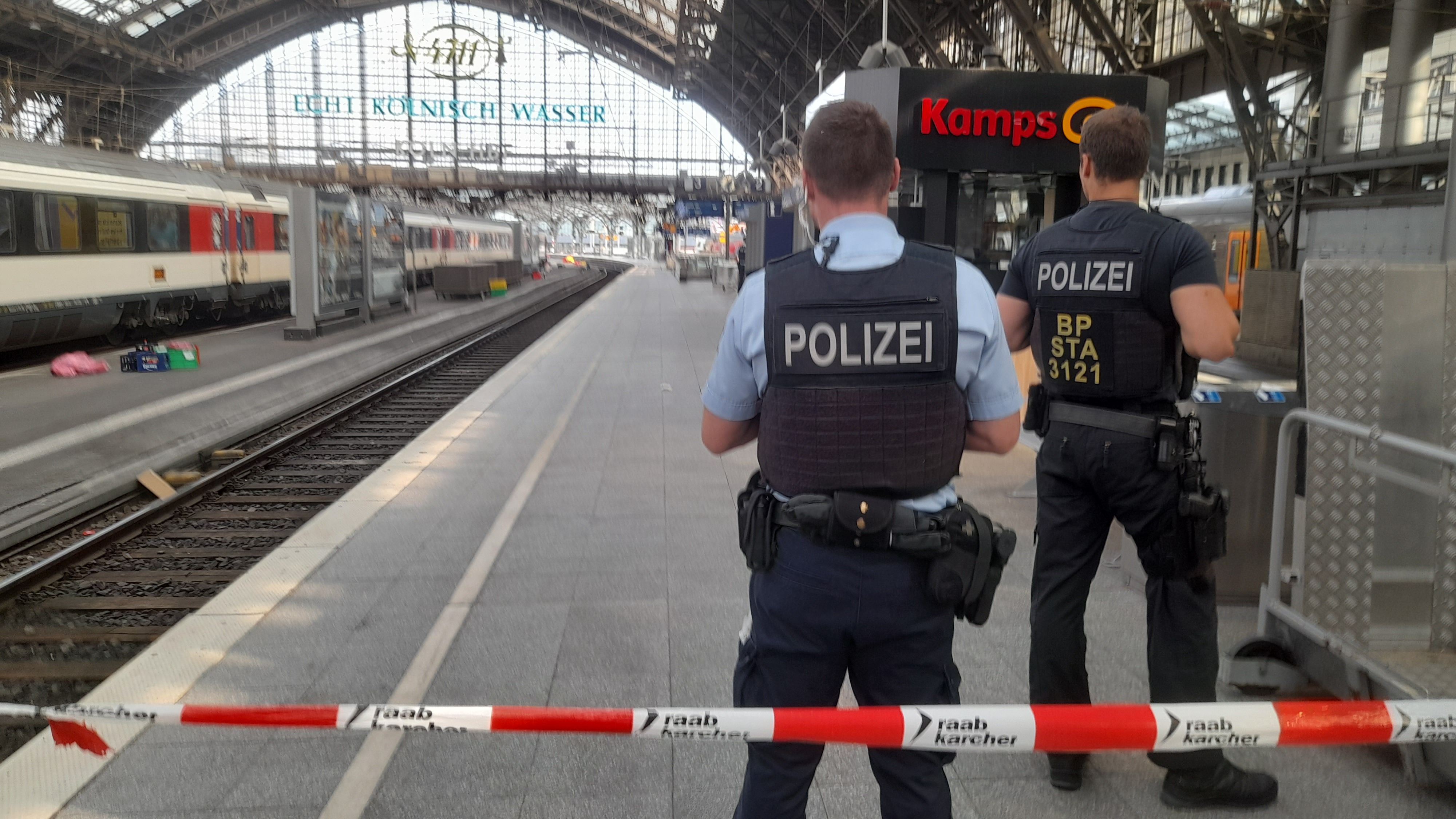 Bundespolizisten stehen auf einem der gesperrten Gleise am Freitagabend, nachdem ein Gepäckstück ohne zunächst erkennbaren Eigentümer gefunden wurde.