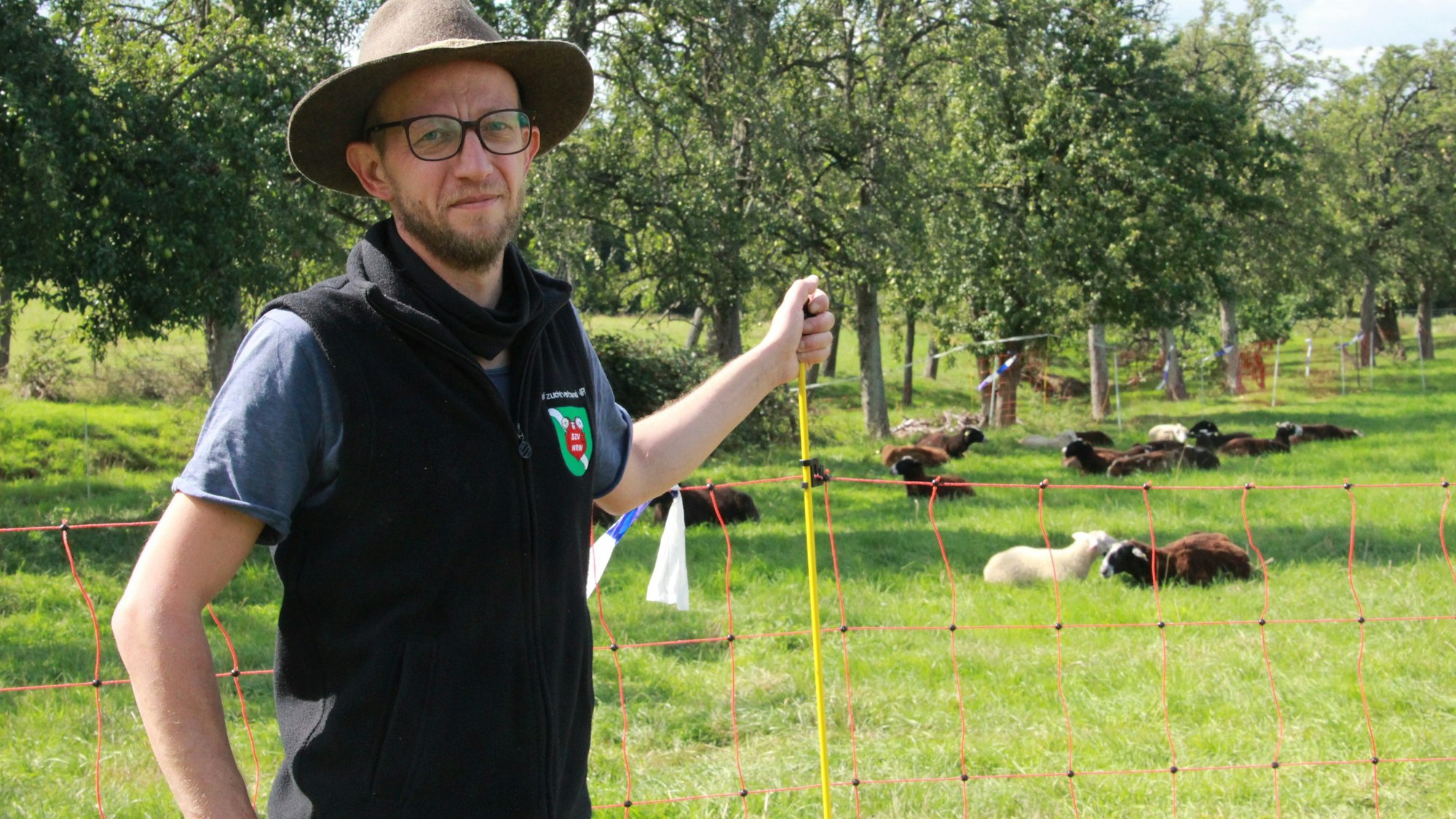 Schafhalter Simon Darscheid aus Hennef-Söven stet am Zaun, der seine Herde schützt.