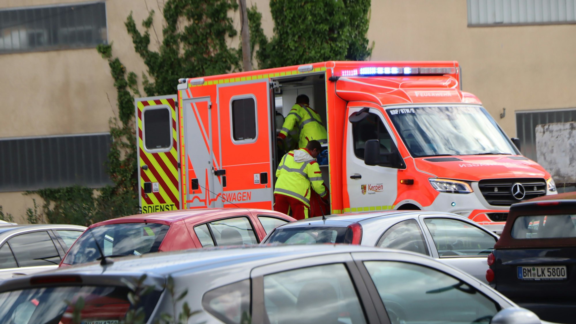 Einsatzkräfte steigen in einen Rettungswagen.
