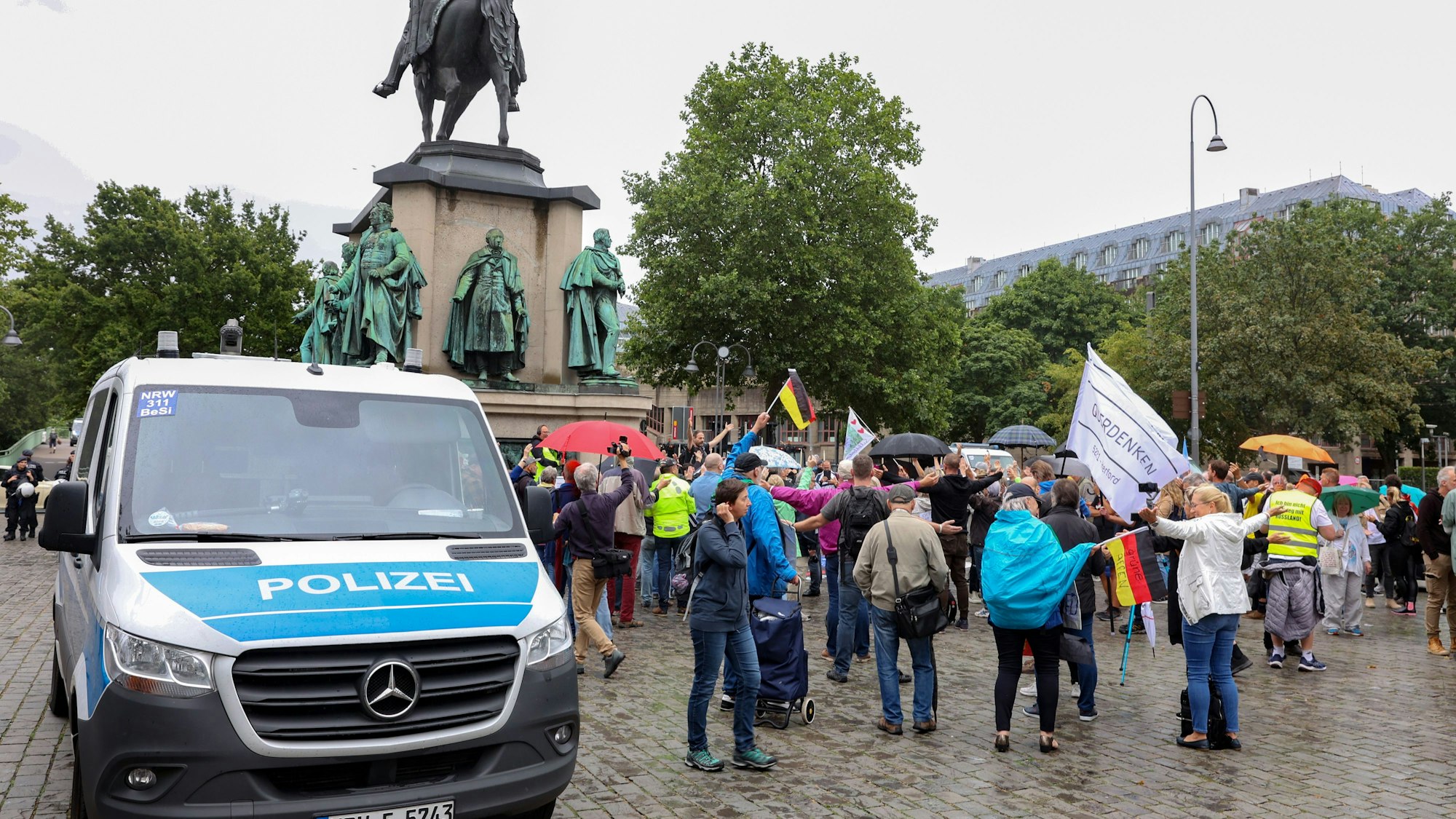Rund 50 Personen kamen zu der Demonstration von „NRW erwacht“ am Kölner Heumarkt, neben Deutschland- wurden auch Querdenker-Fahnen geschwenkt. Es gab einen Gegenprotest.