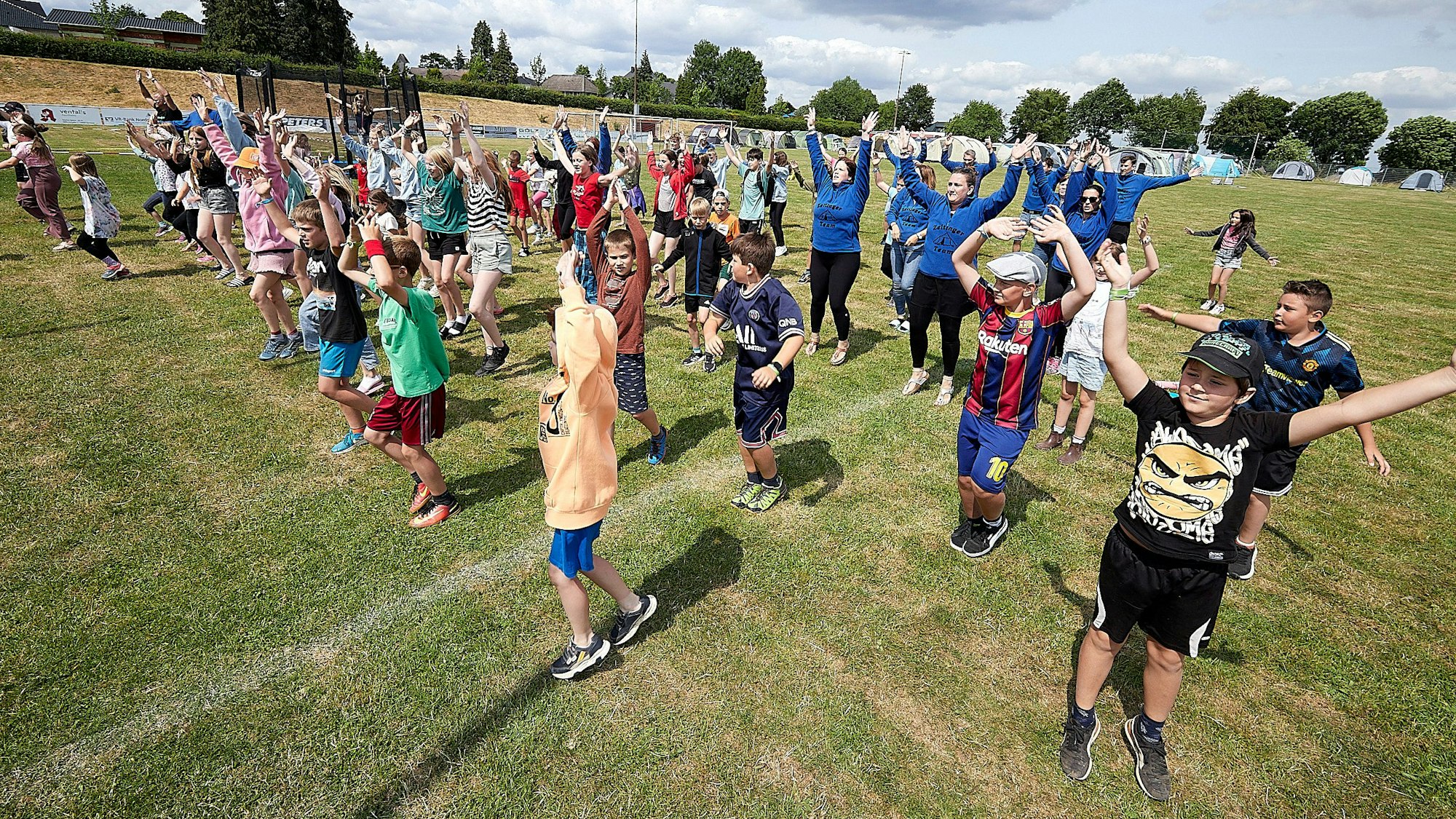 Die teilnehmenden Kinder absolvieren auf ihrem Zeltplatz ein Sporttraining.