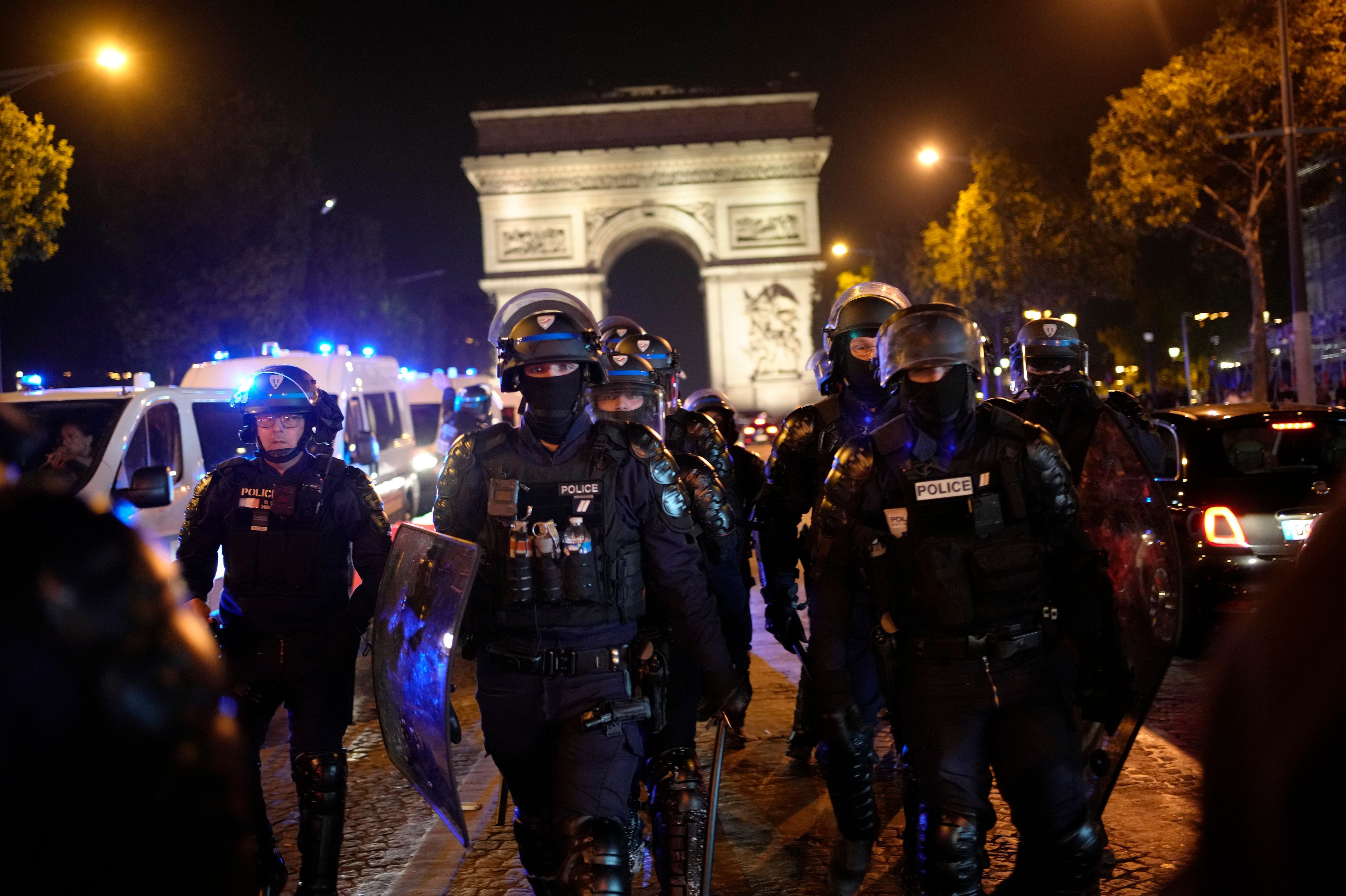Frankreich, Paris: Polizisten patrouillieren vor dem Arc de Triomphe auf der Champs Élysées.