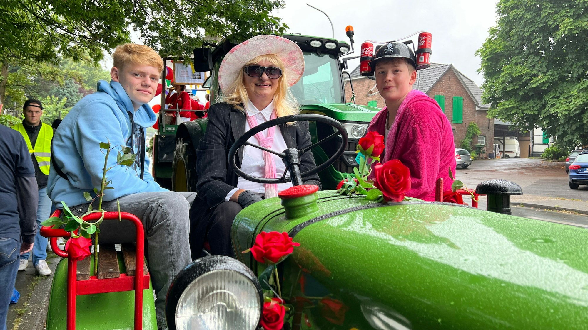 Gleich hinter dem Spielmannszug kommt Rita Küster auf einem Traktor mit den beiden 15-jährigen Jonathan Rothe und Berno Ley.