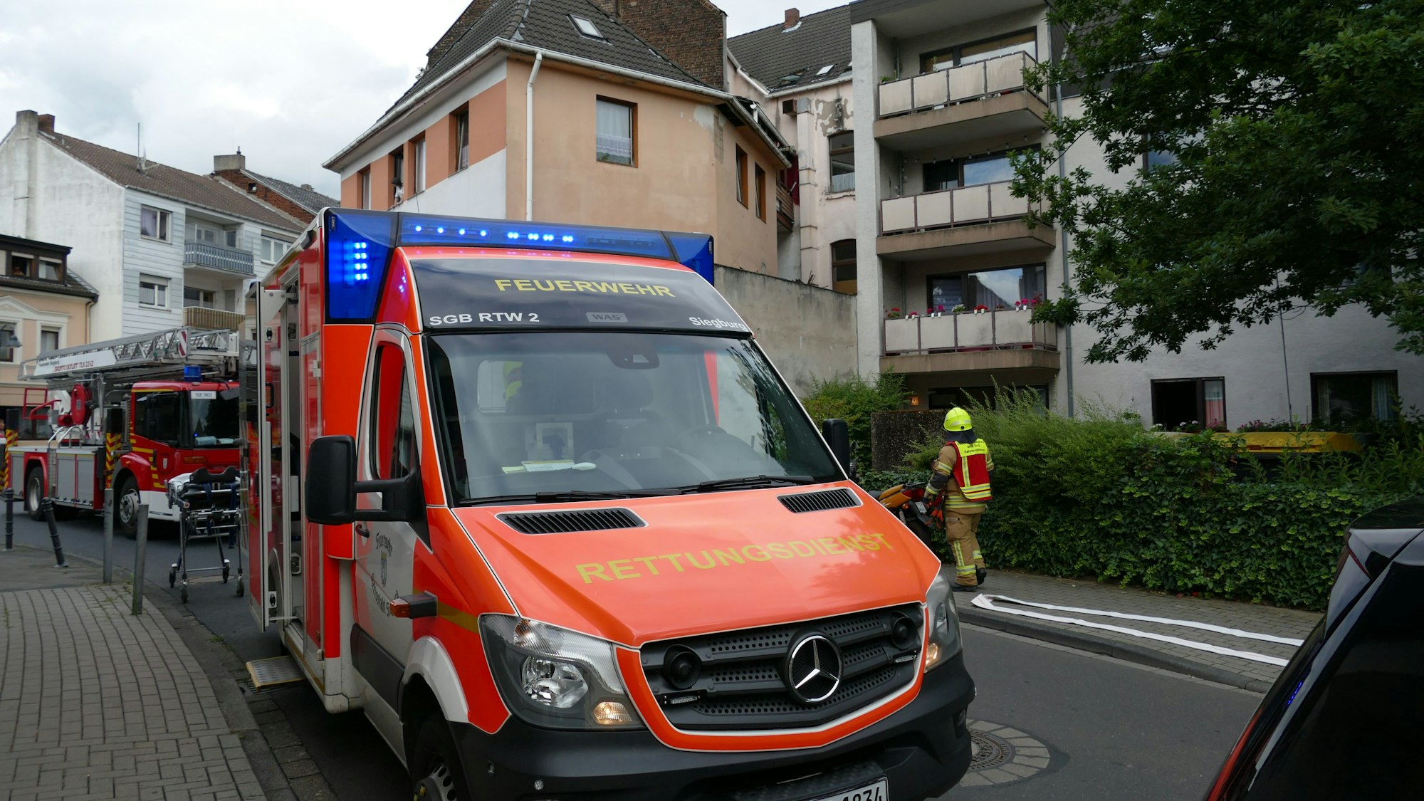 Ein Rettungswagen steht vor einem Mehrfamilienhaus.
