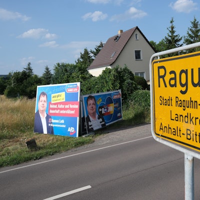 Das Ortseingangsschild von Raguhn, im Hintergrund Wahlwerbung des AfD-Kandidaten Hannes Loth.