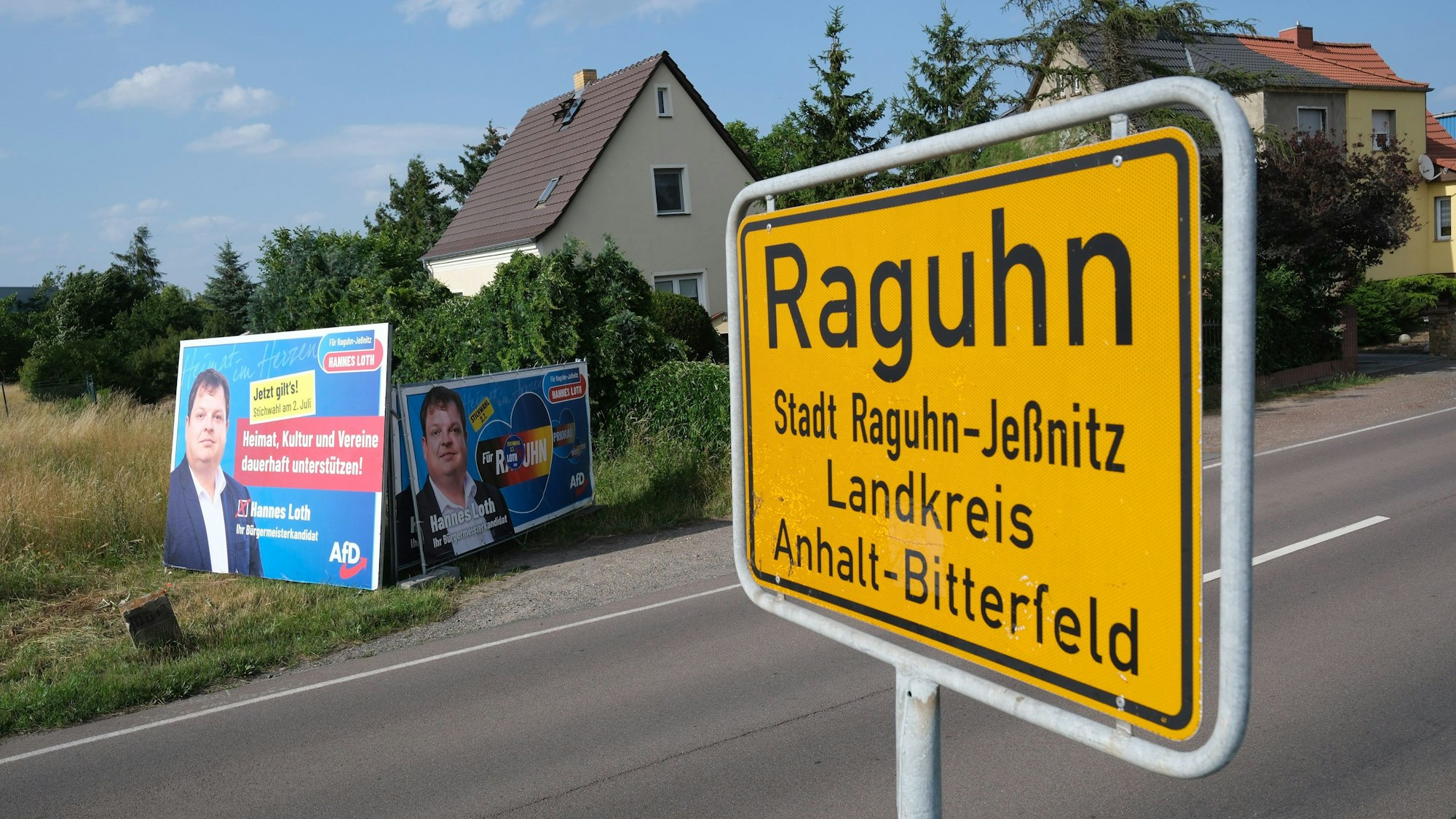 Das Ortseingangsschild von Raguhn, im Hintergrund Wahlwerbung des AfD-Kandidaten Hannes Loth.