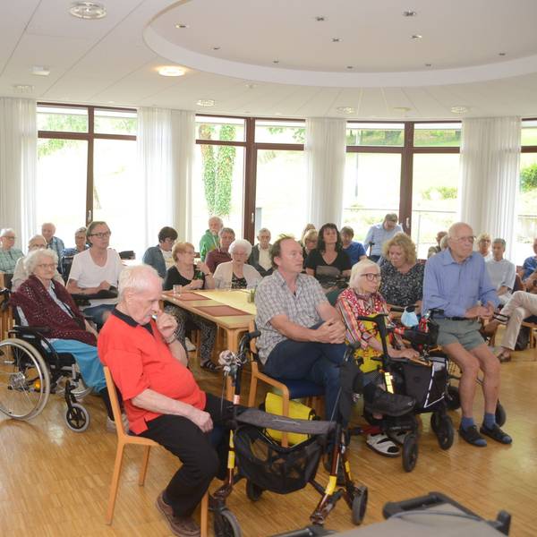 Senioren sitzen auf Stühlen.
