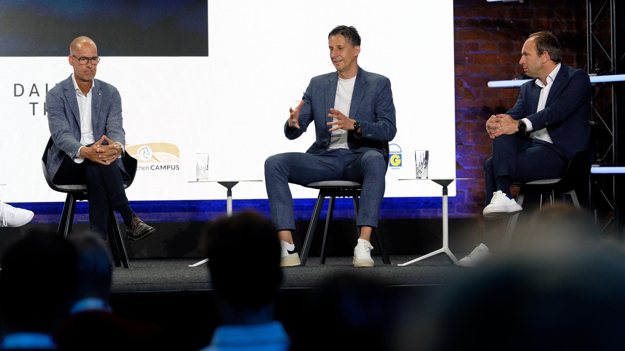 Carsten Cramer, Geschäftsführer Borussia Dortmund, Christian Keller, Geschäftsführer 1. FC Köln und Alexander Jobst, CEO Fortuna Düsseldorf (v-l), diskutieren auf der Bühne.