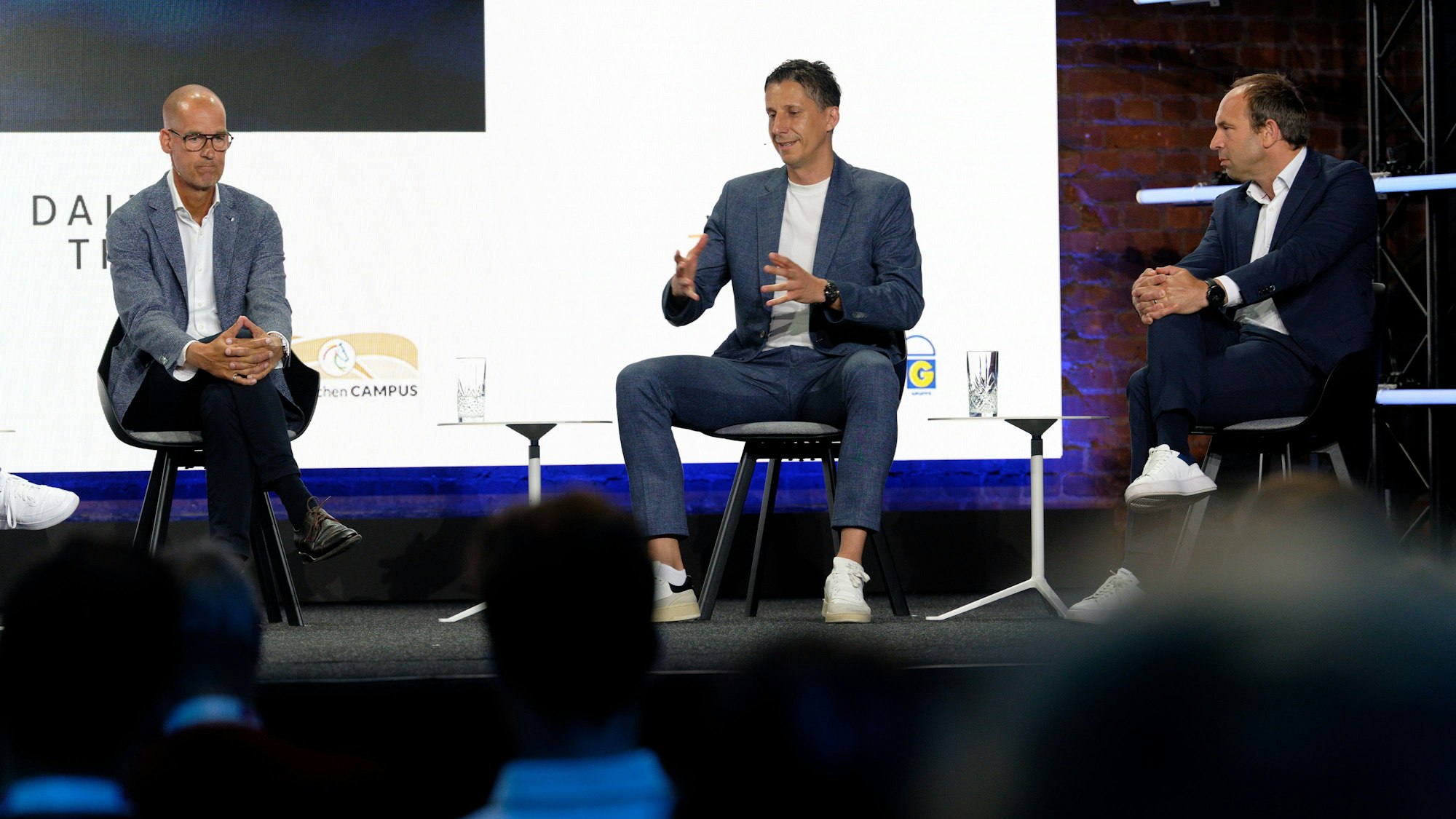 Carsten Cramer, Geschäftsführer Borussia Dortmund, Christian Keller, Geschäftsführer 1. FC Köln und Alexander Jobst, CEO Fortuna Düsseldorf (v-l), diskutieren auf der Bühne.