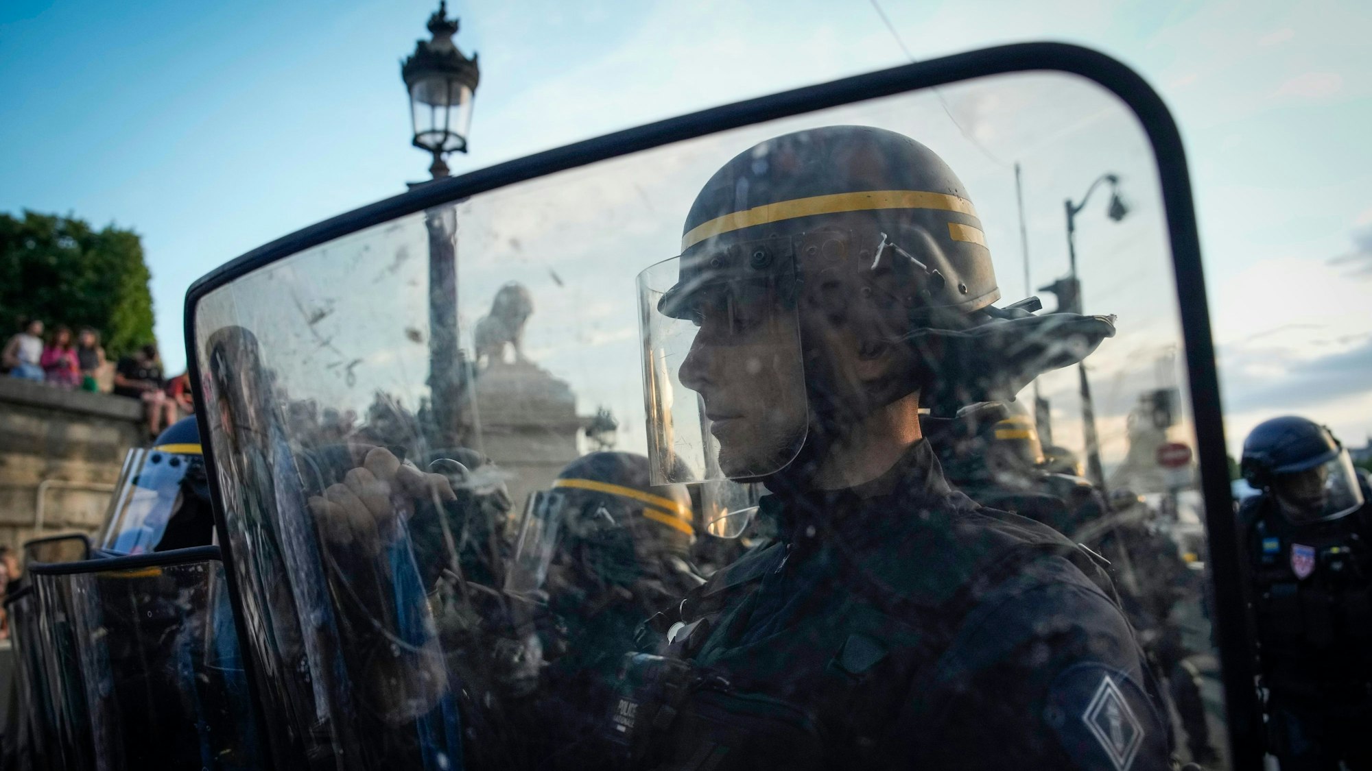 Polizisten stehen vor Demonstranten auf dem Place de la Concorde während der Demonstration. Drei Tage nach dem tödlichen Schuss eines Polizisten auf einen Jugendlichen bei einer Verkehrskontrolle bei Paris ist es erneut zu Krawallen in Frankreich gekommen.