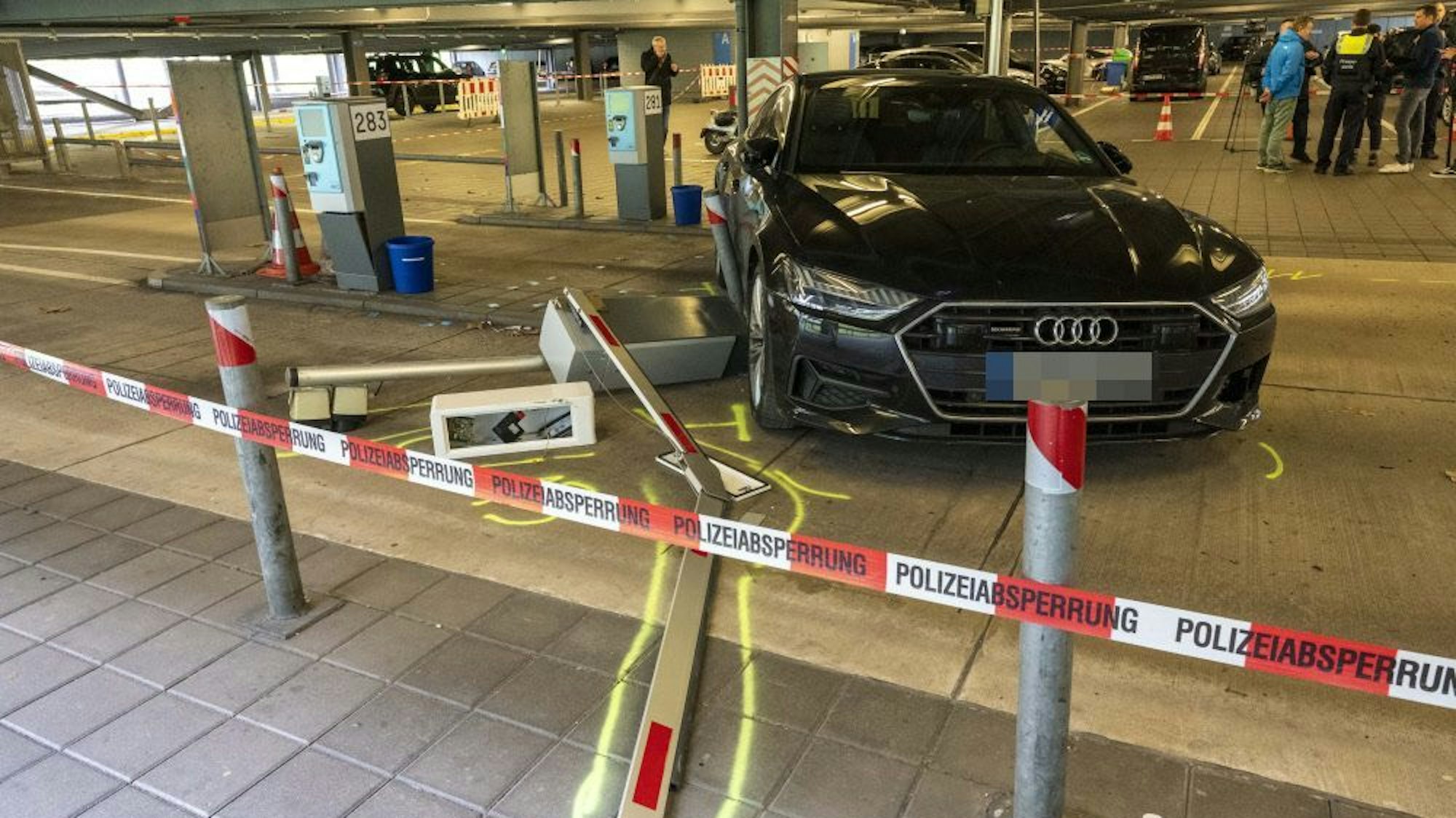 Ein demoliertes Auto steht neben einer Parkhausschranke, die aus der Verankerung gerissen wurde.