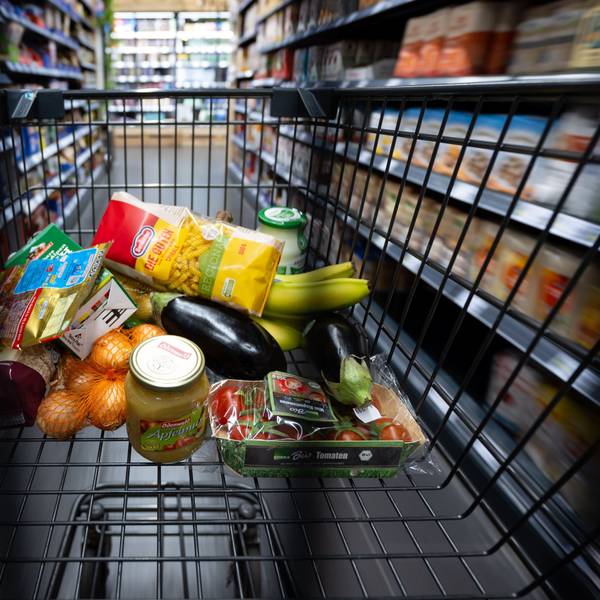 Verschiedene Lebensmittel liegen in einem Supermarkt in einem Einkaufswagen.