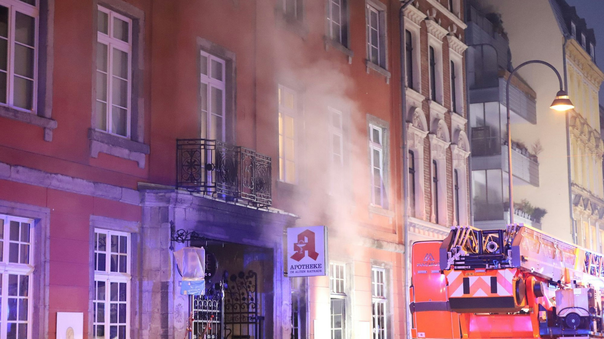 Rauch steigt aus der Apotheke im Alten Rathaus an der Deutzer Freiheit. Neben der Apotheke steht ein Feuerwehrauto.
