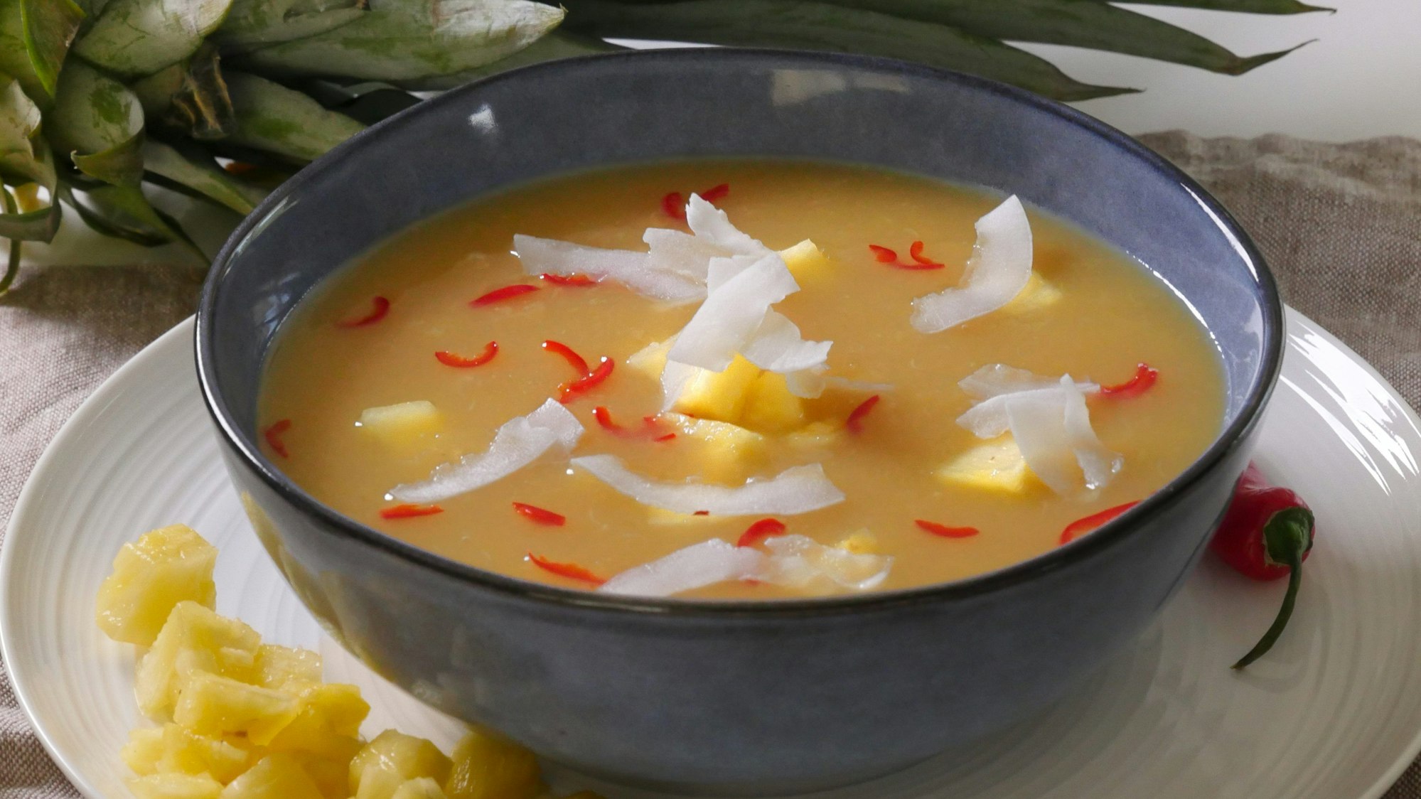 Ananas-Kaltschale mit Chiliflocken, Kokoschips und Ananas-Stücken