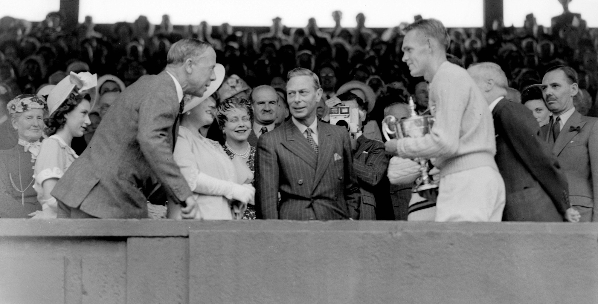 König Georg VI. überreicht dem Amerikaner Jack Kramer 1947 die Trophäe im Einzel. Ganz links sieht man auch die spätere Königin Elizabeth.