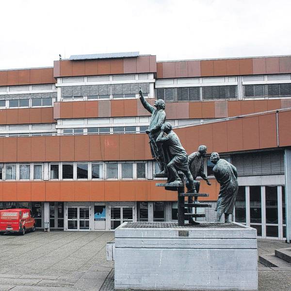 Das Kopernikus-Gymnasium im Schulzentrum Nord in Niederkassel mit einem Denkmal im Vordergrund.