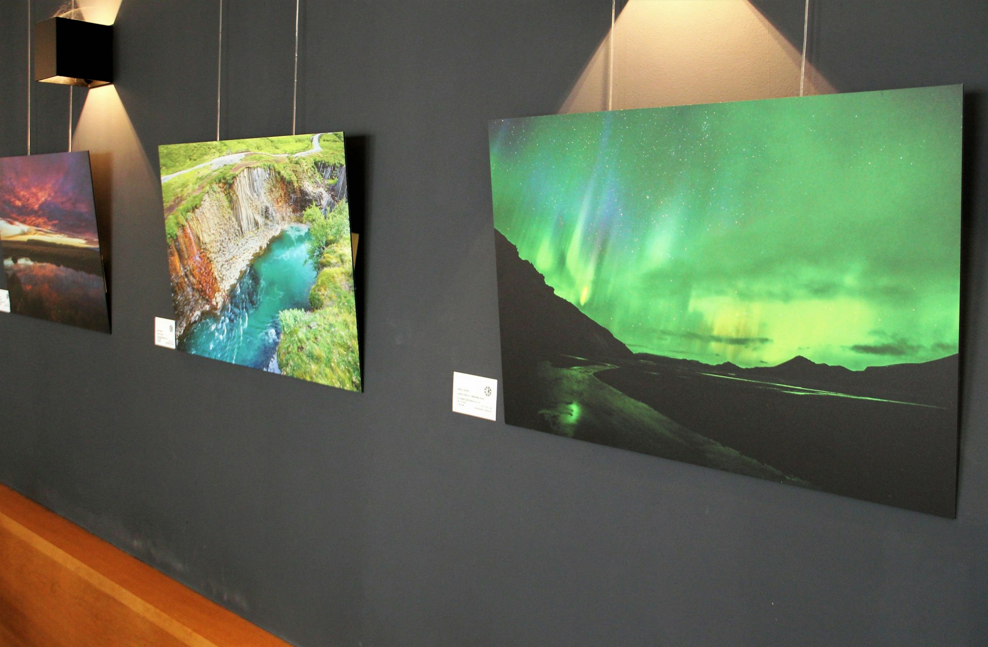 Auf einem Bild sind Polarlichter zu sehen, auf einem anderen ein Flusslauf zwischen steilen Abhängen.
