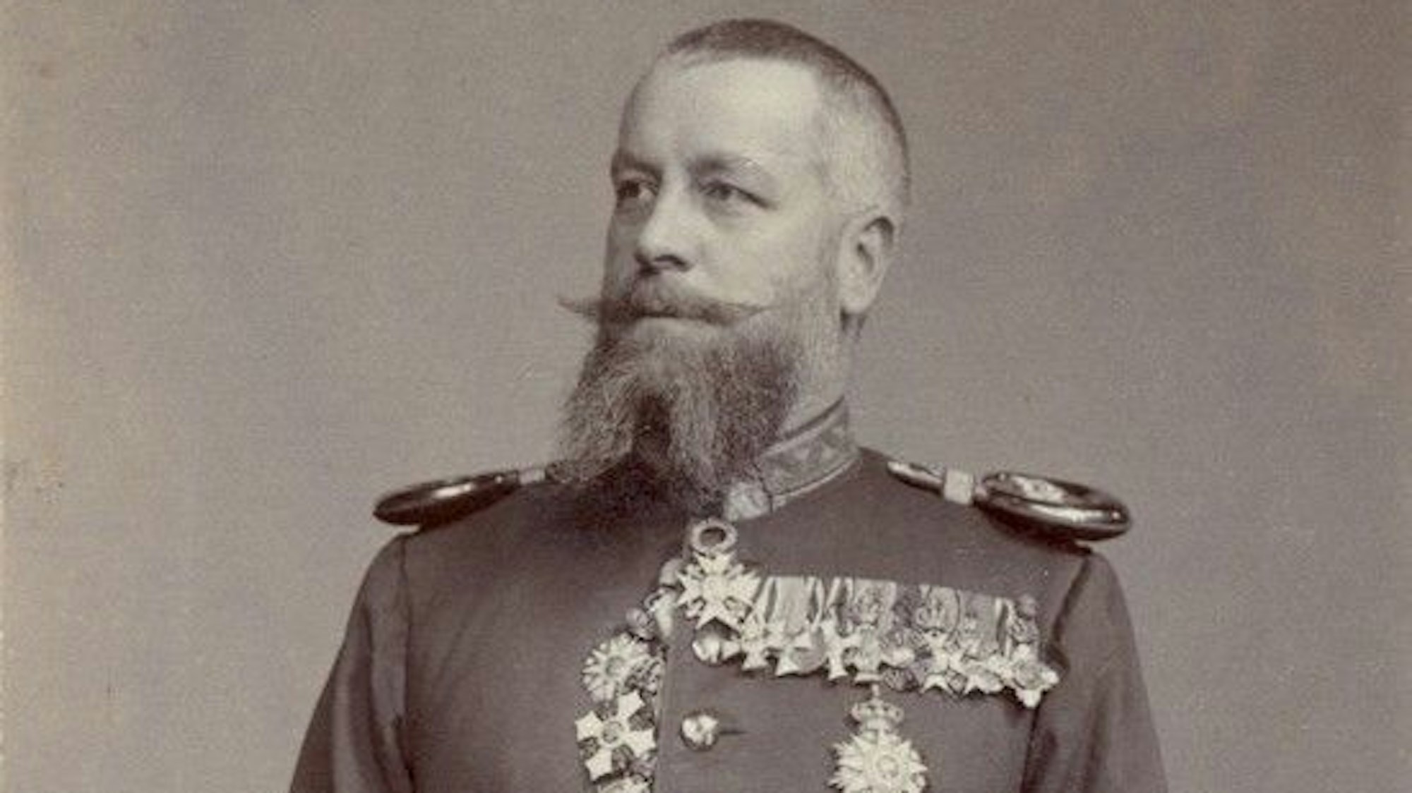 Der Sammler Wilhelm Joest posiert mit Uniform und Orden für die Kamera.