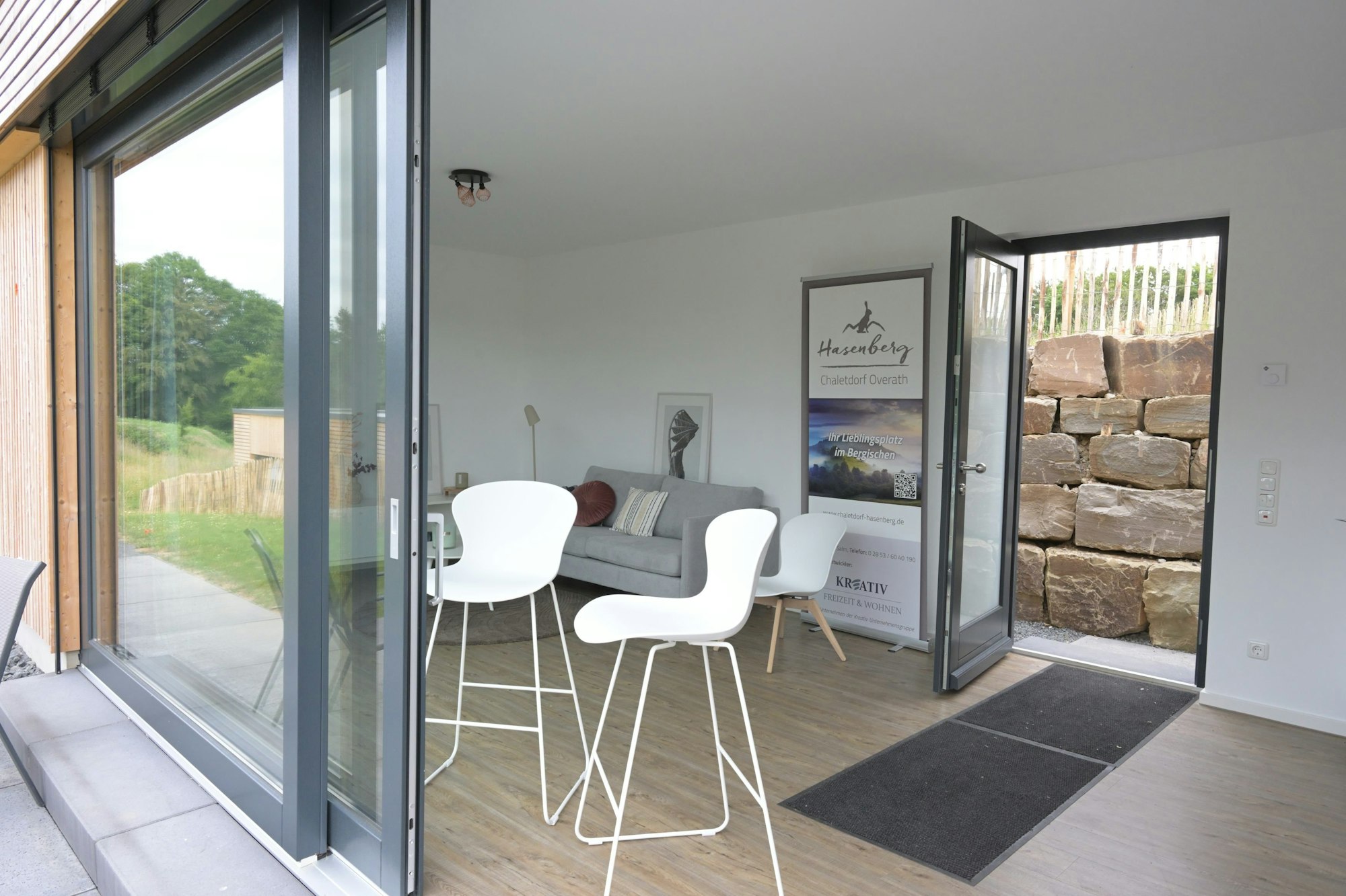 Eine Couch und zwei Hocker stehen in einem Wohnraum.