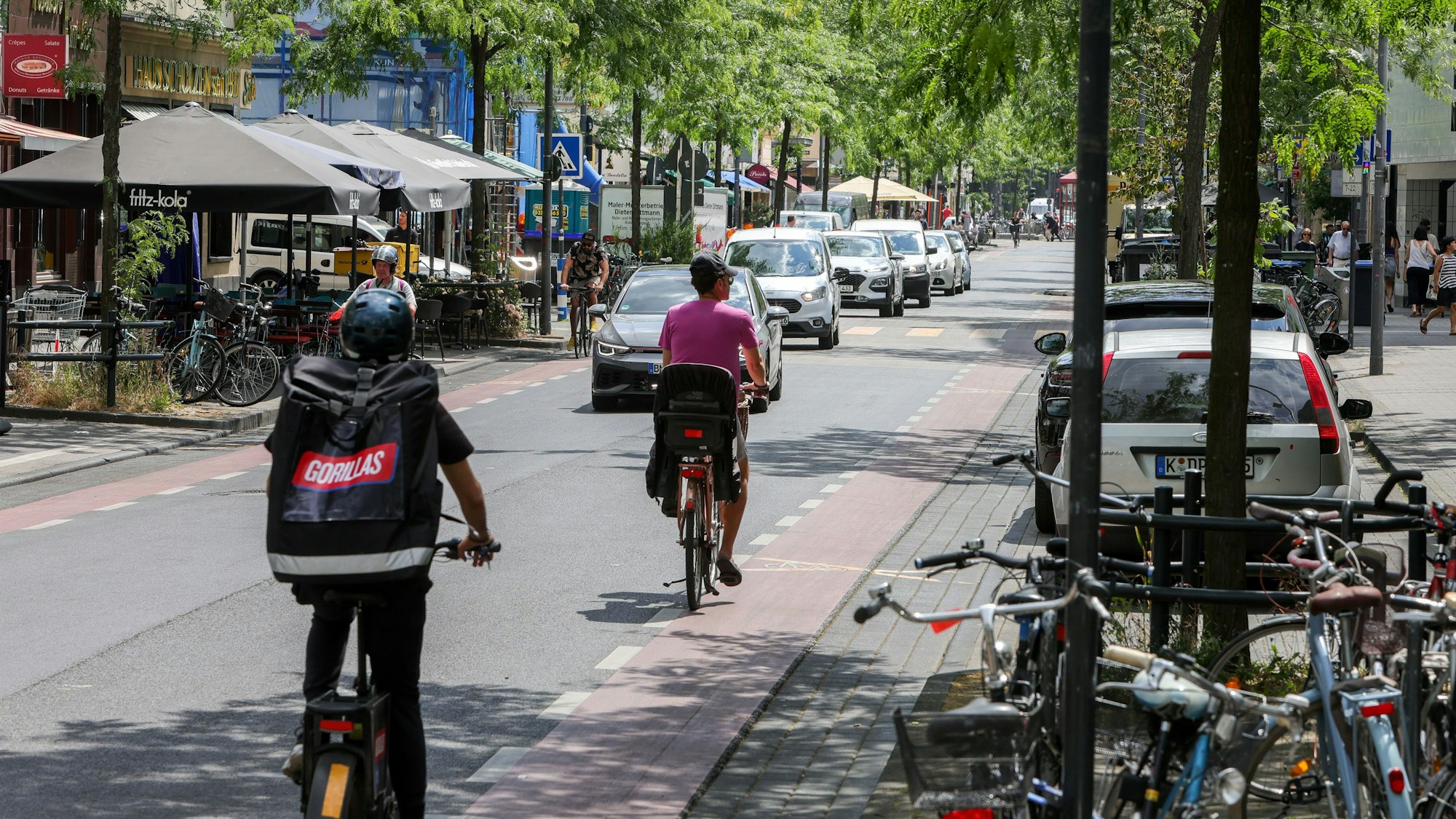 Fahrradfahrer fahren über die Venloer Straße in Köln-Ehrenfeld.