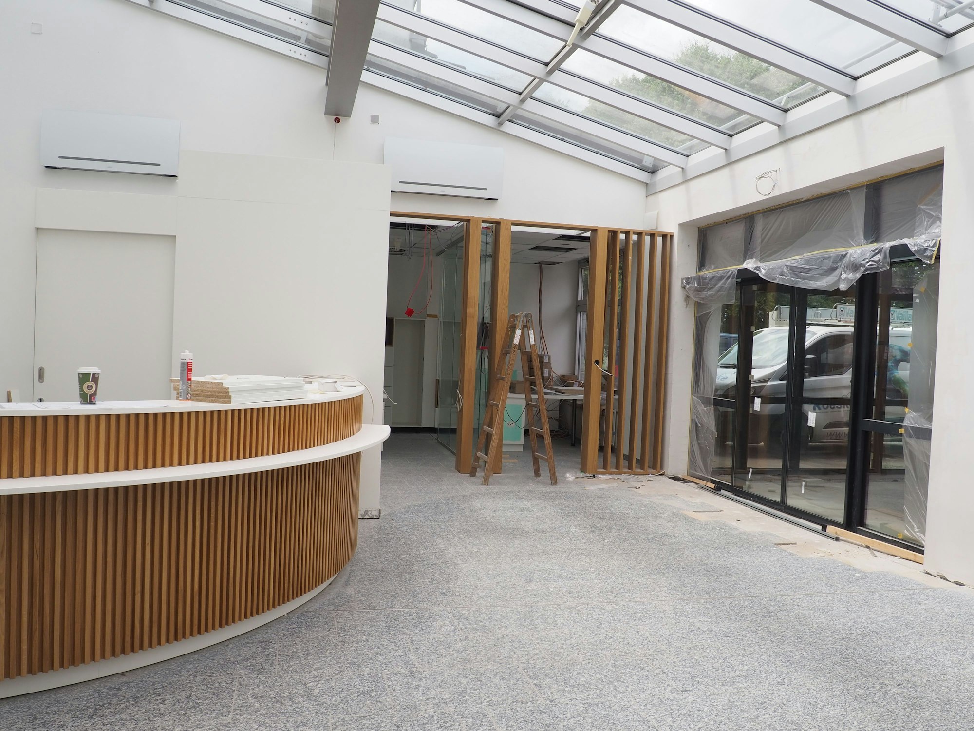 In einem offenen Raum, der wie ein Eingangsbereich aussieht, steht auf der linken Seite eine Theke.