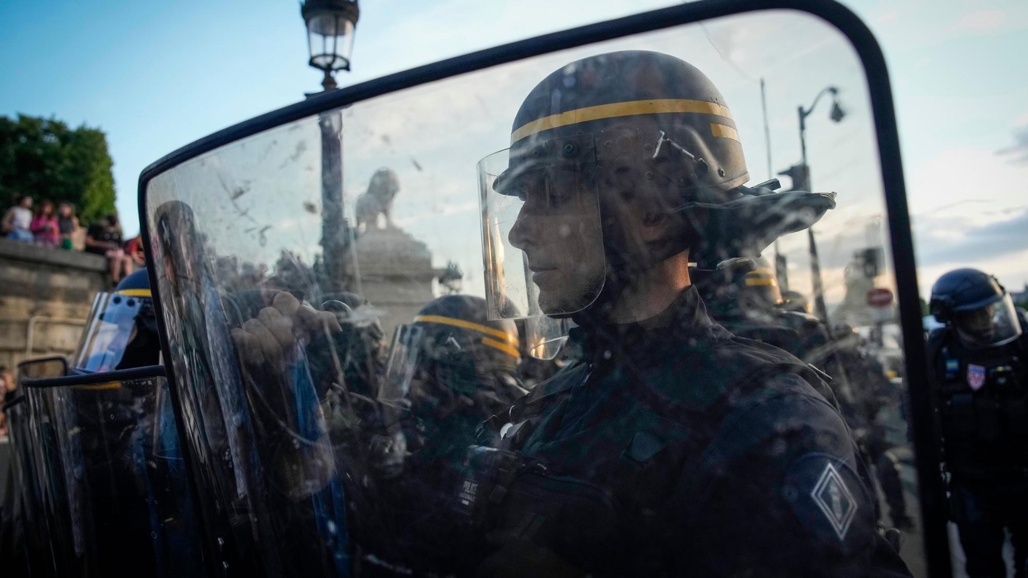 Polizisten stehen vor Demonstranten auf dem Place de la Concorde in Paris.