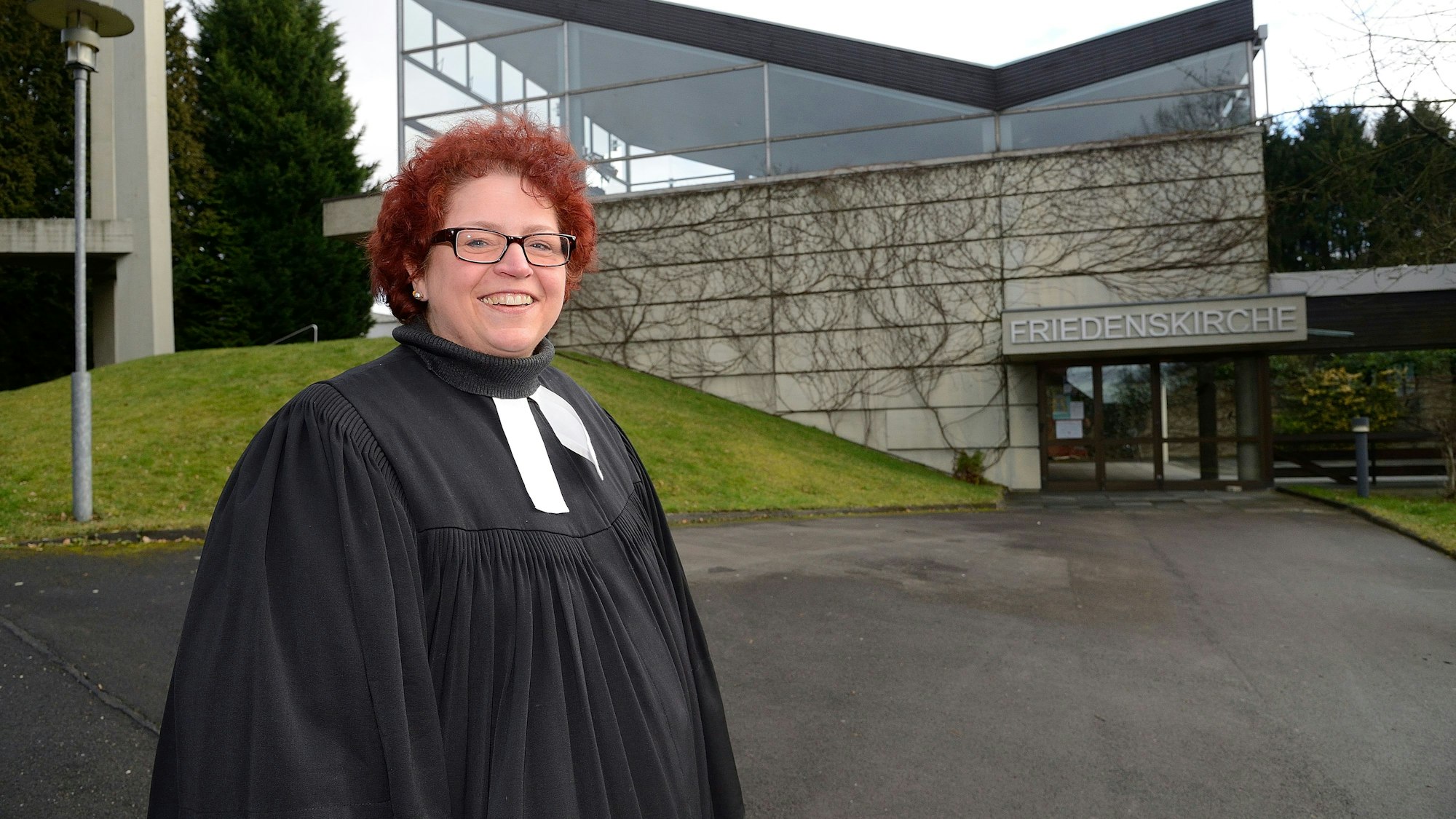 Pfarrerin Martina Palm steht Anfang 2014 vor der Friedenskirche in Overath-Neichen.