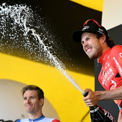 Phil Bauhaus feiert auf dem Podium mit Champagner seinen Etappensieg