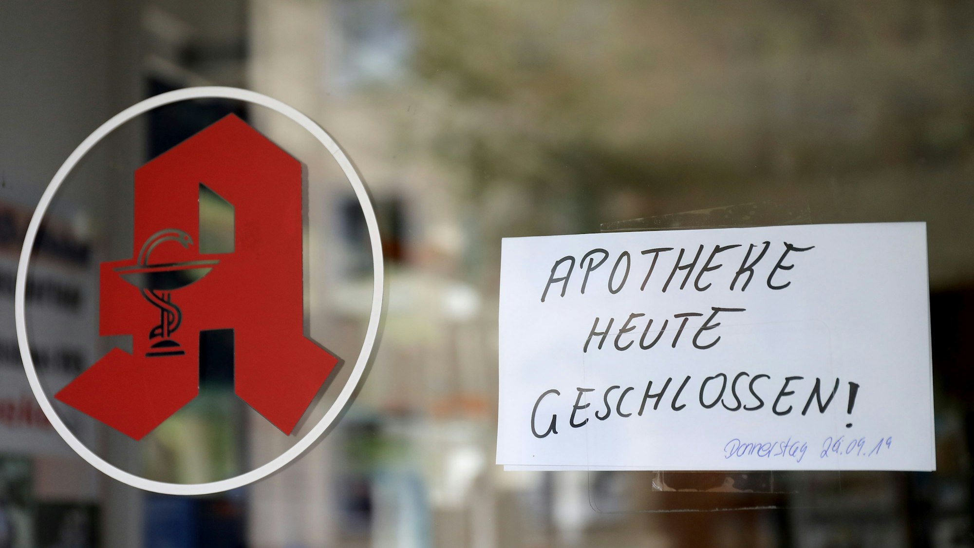 Ein Schild »Apotheke heute geschlossen« hängt in der Tür einer Apotheke.