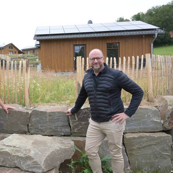 Harald Daunheimer und Matthias Korte stehen vor einer halbhohen Mauer aus großen Begrenzungssteinen.