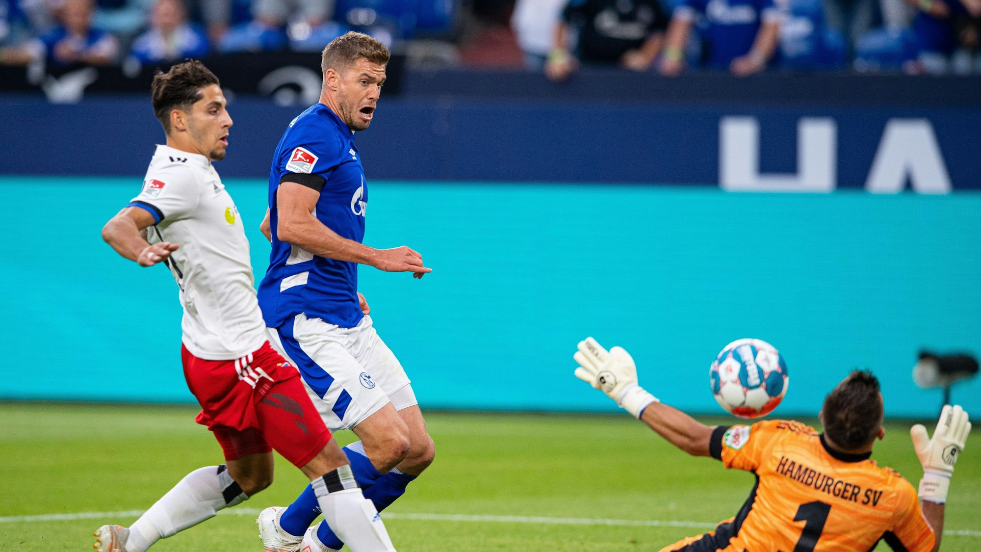 Schalkes Simon Terodde (M) erzielt gegen Hamburgs Ludovit Reis (l) und Hamburgs Torwart Daniel Heuer Fernandes das Tor zum 1:0.