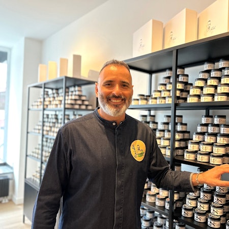 Ein Mann steht vor einem Regal mit Gewürzgläsern.