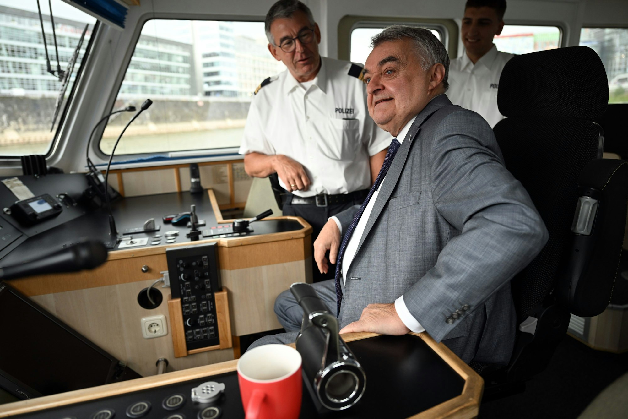 05.07.2023, Nordrhein-Westfalen, Düsseldorf: Herbert Reul (CDU, r), Innenminister von Nordrhein-Westfalen, sitzt im Steuerstand des Wasserschutzbootes WSP1 und spricht mit Hauptkommissar Jakob Schmitz (l). Reul informierte sich bei dem Besuch über die Arbeit der Wasserschutzpolizei auf dem Rhein. Foto: Federico Gambarini/dpa +++ dpa-Bildfunk +++