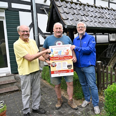 Heinz Schmitz, Franz Grimberg und Jörg Jenniges stehen am Mühlrad der Weyermühle in Dürscheid.