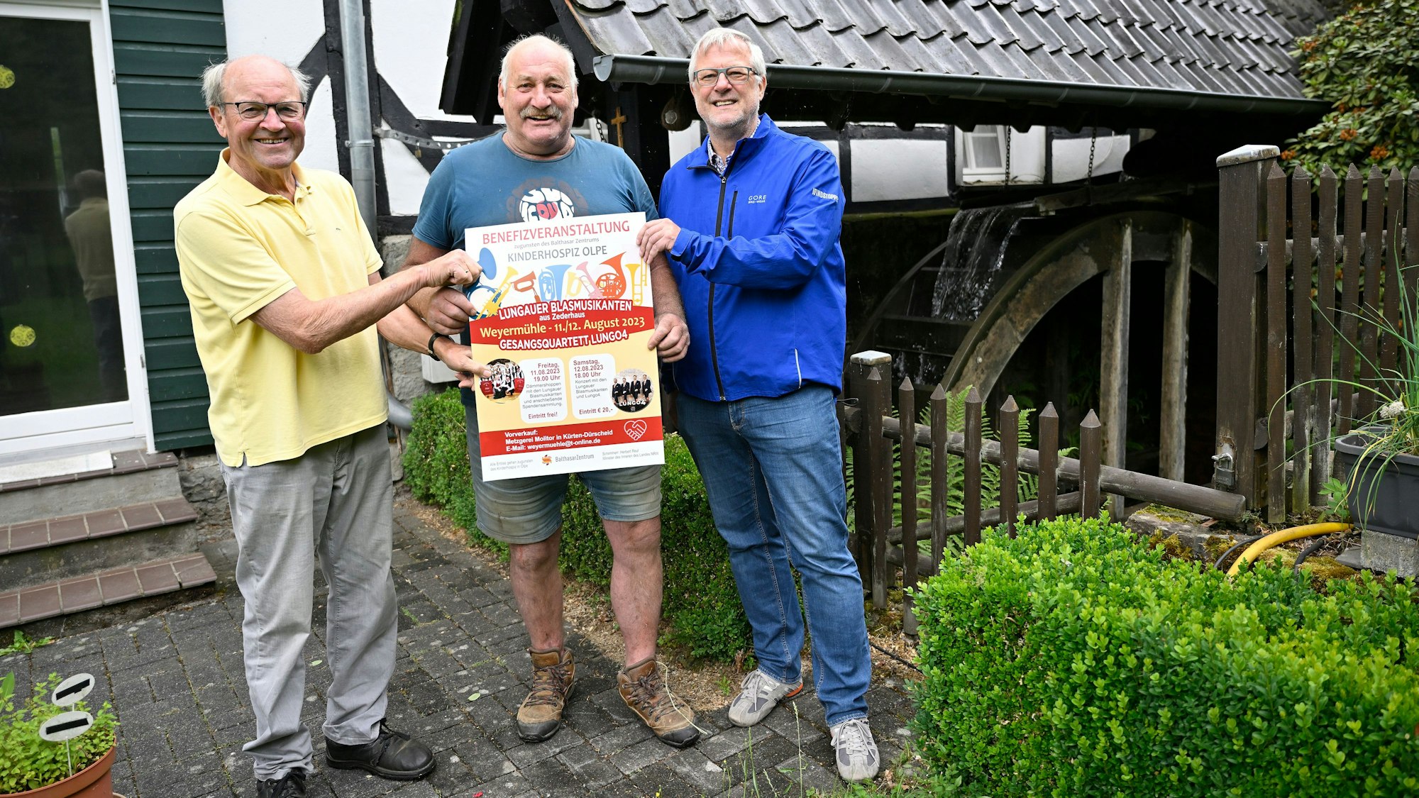 Heinz Schmitz, Franz Grimberg und Jörg Jenniges stehen am Mühlrad der Weyermühle in Dürscheid.