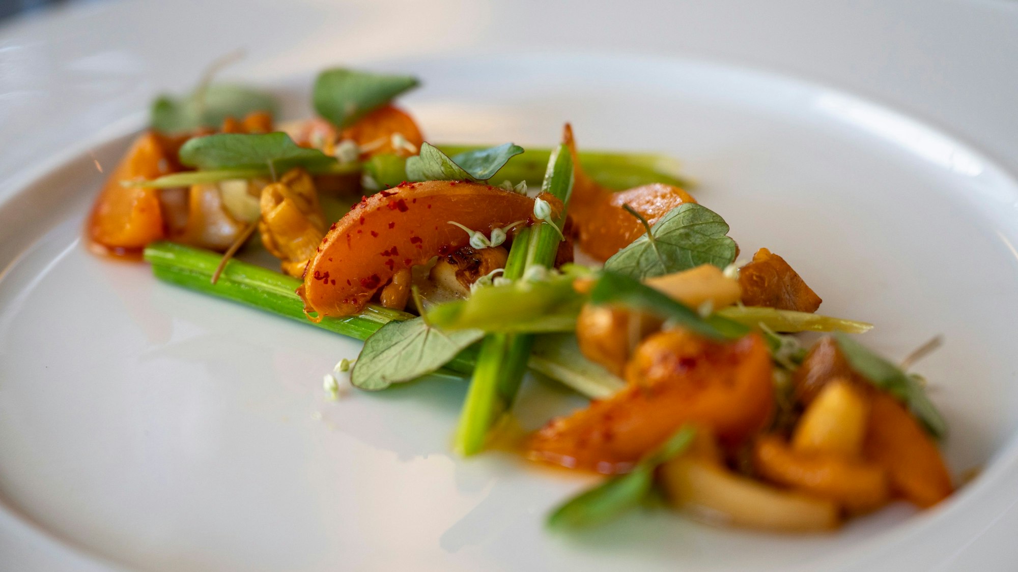 Lauch-Herz und Blüten, Aprikose, Pfifferlinge liegen auf einem Teller.