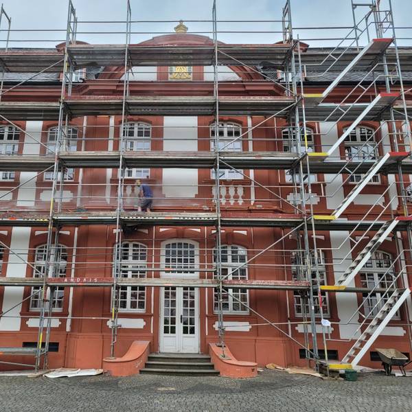 Das Bild zeigt eine Fassade, an der ein Gerüst steht.