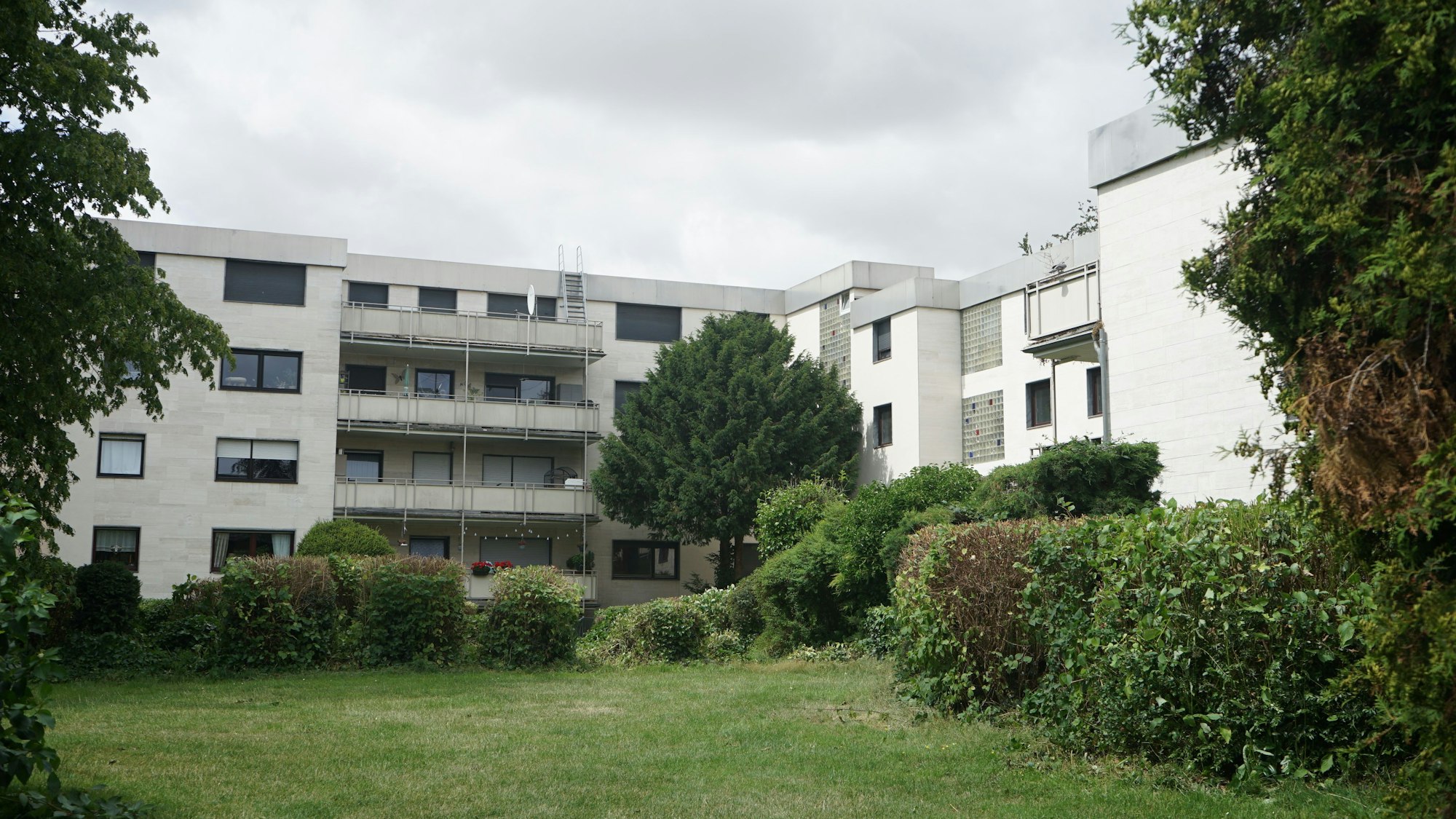 Das Bild zeigt den Aher Wohnpark, einen grau-weißen Betonbau.