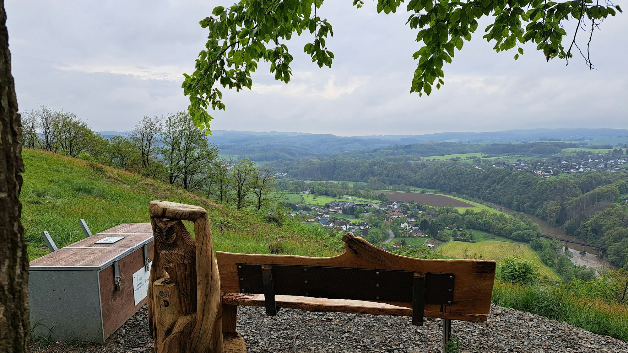 Bank an einem Aussichtspunkt, links daneben eine große Holzkiste